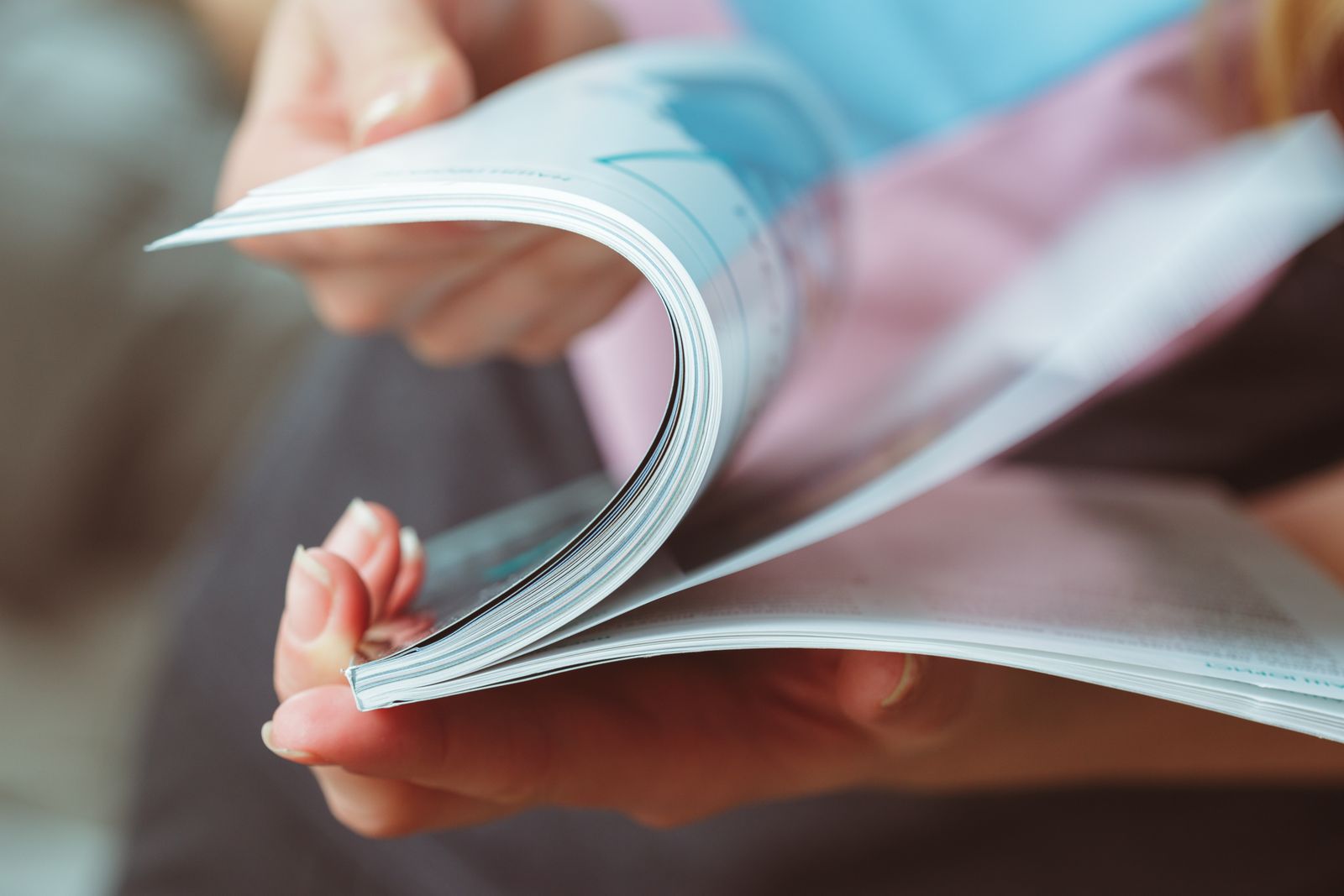 Hände blättern durch ein gedrucktes Magazin