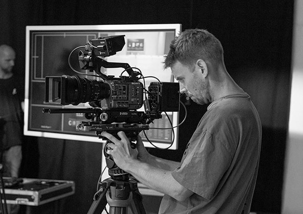 Kameramann mit Kinokamera auf dem Stativ bei einer Produktion im fourplex Studio