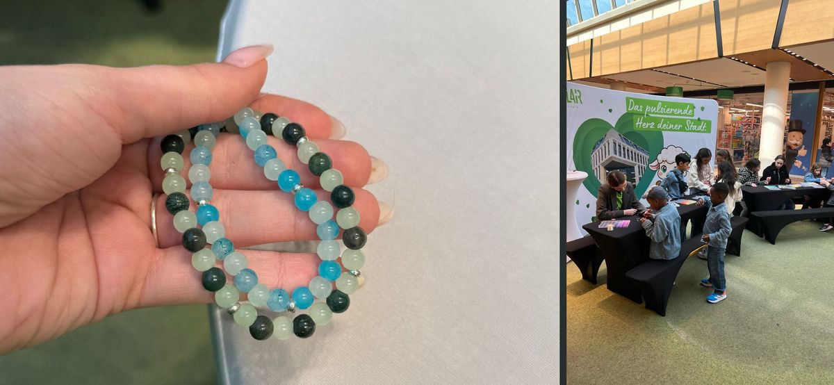 Selbst gebasteltes Perlenarmband in der Hand und Kinder am Basteltisch im FLAiR Fürth