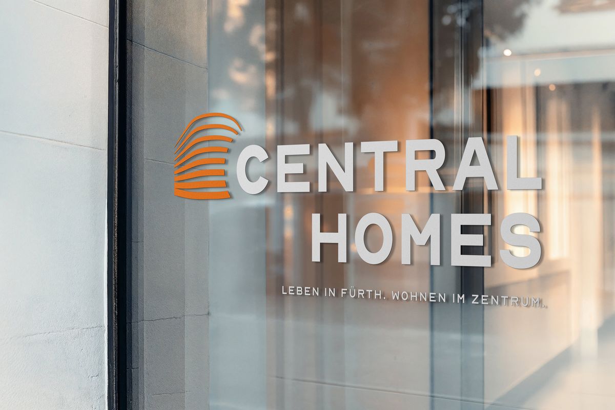Central-Homes-Logo mit orangefarbener Bildmarke und dem Claim „Leben in Fürth. Wohnen im Zentrum.“ als Beschriftung auf einer Glasfassade