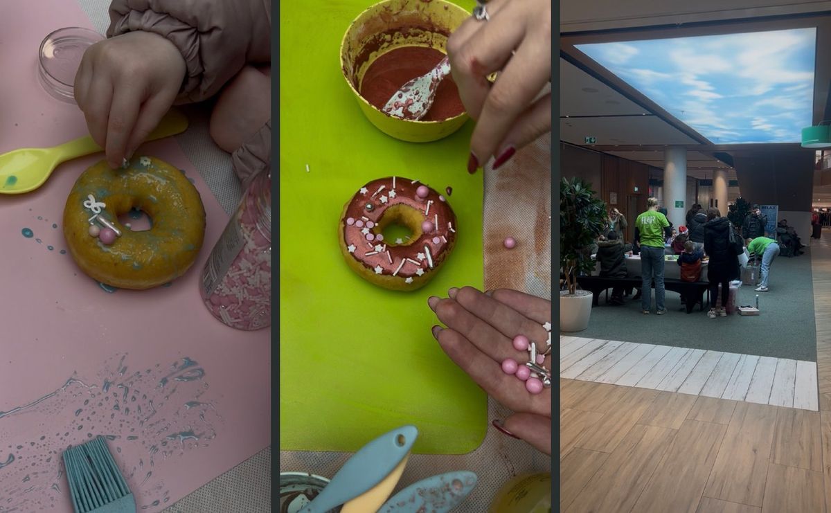 Kinderhände verzieren Donuts mit Zuckerguss und Streuseln, dahinter die Backstation unter dem Glasdach des FLAiR Fürth