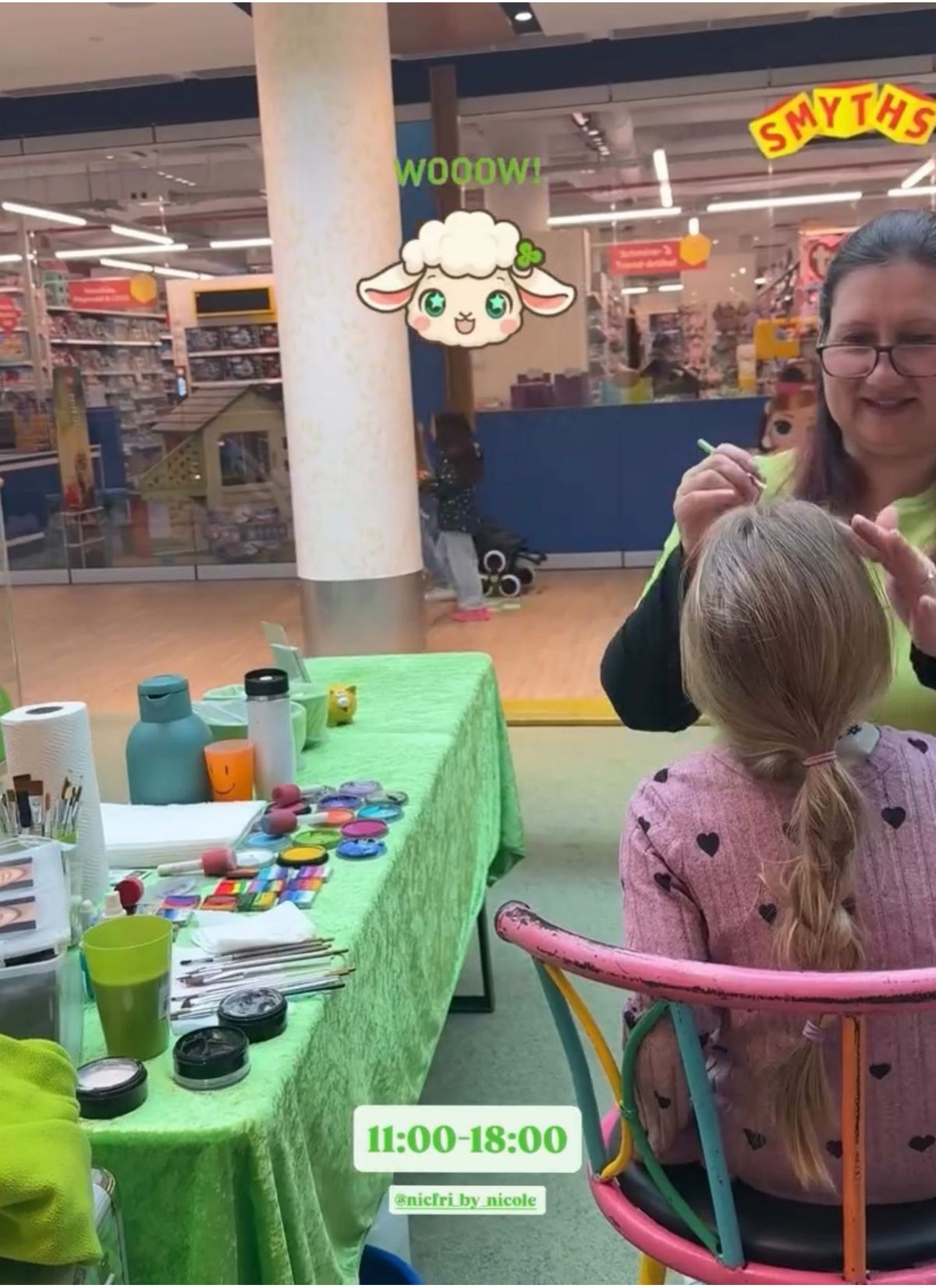 Schminkerin bemalt ein Kind am grünen Aktionstisch im FLAiR Fürth